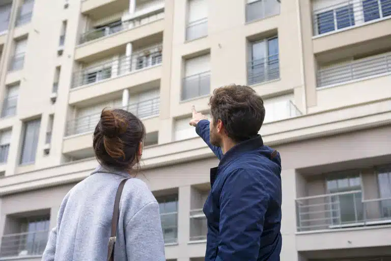 Couple observant façade d'immeuble et fenêtres